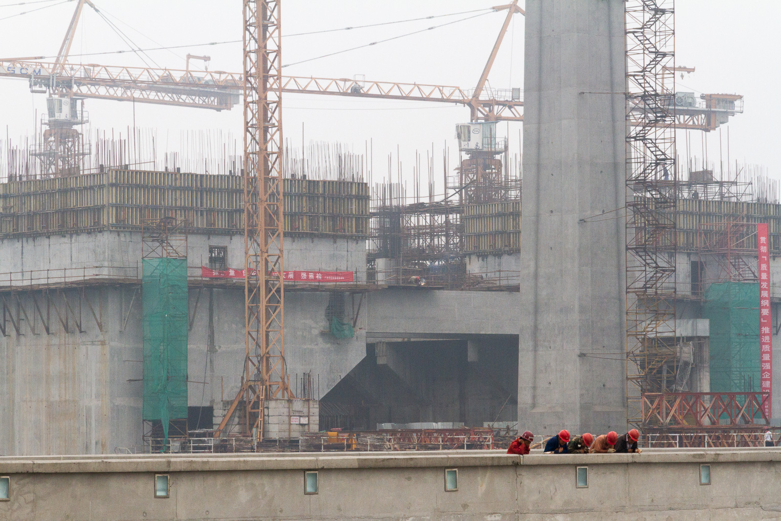 Workers watching a cleaning boat below the Three Gorges Dam